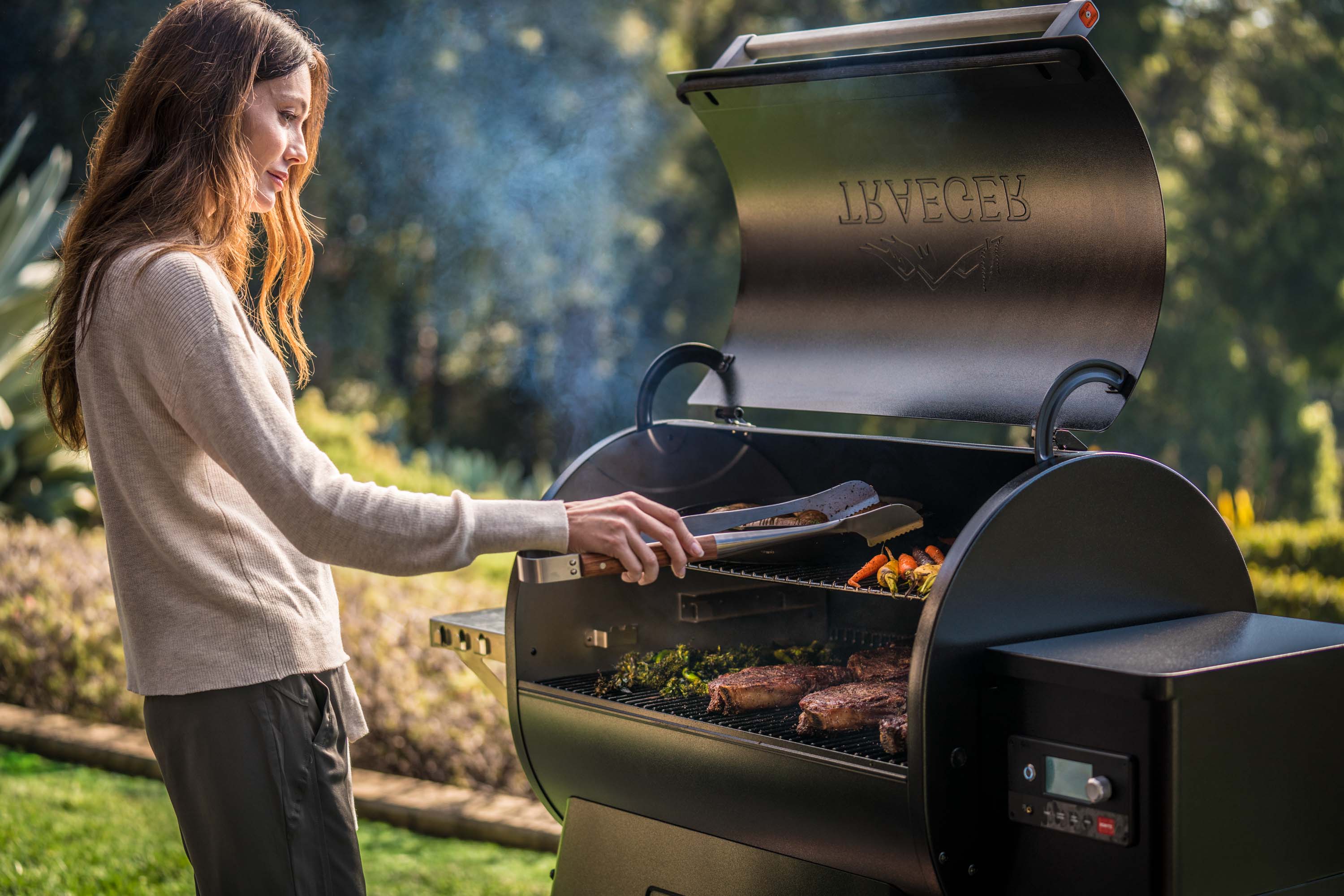 Long-haired woman barbecuing outside