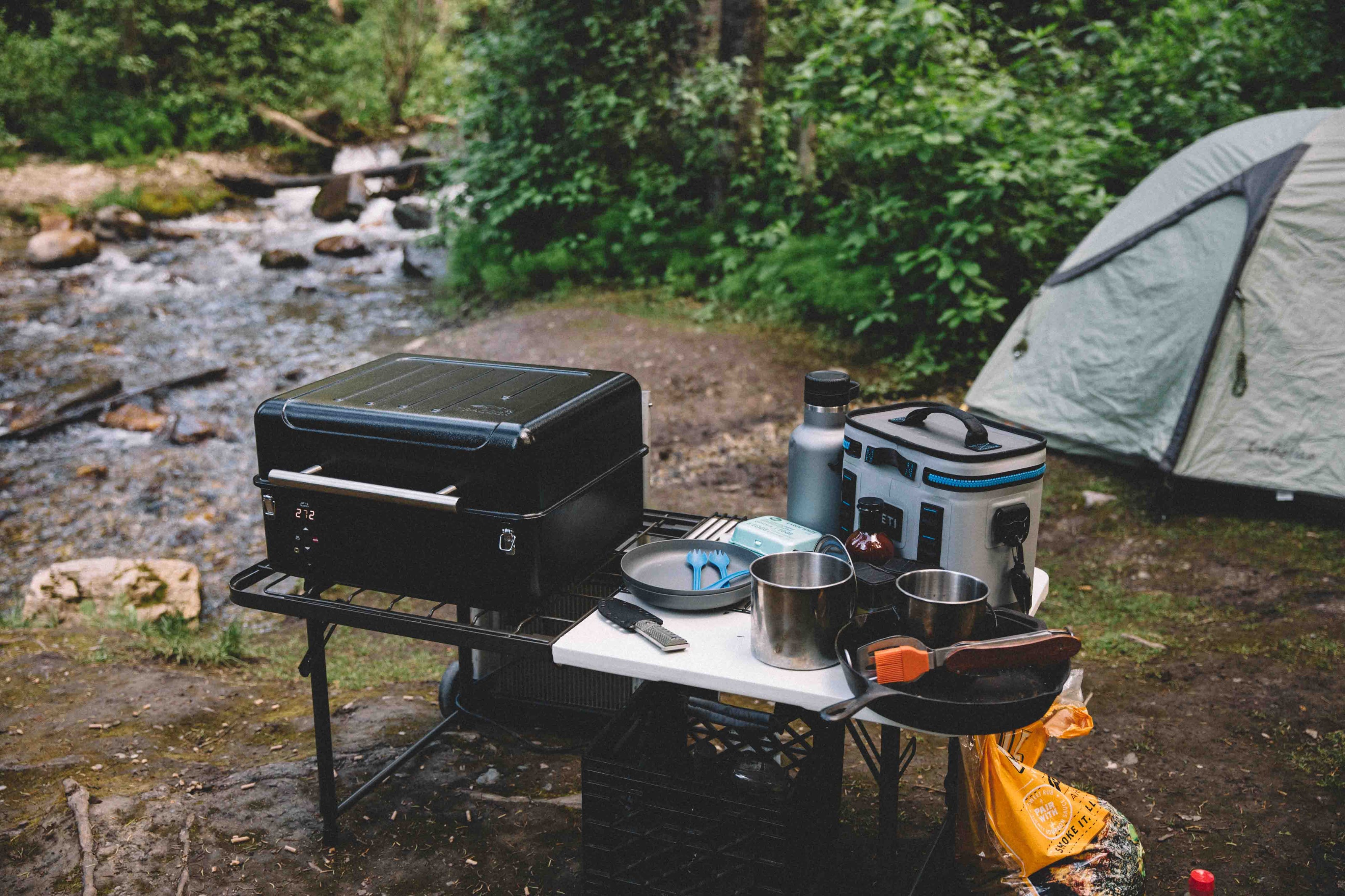 Camping barbecue equipment next to a stream