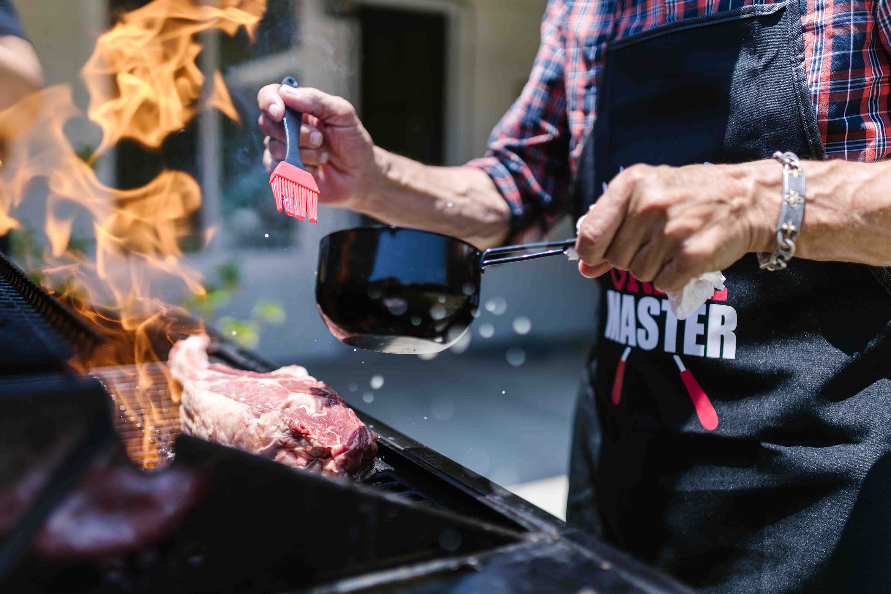 A person barbecuing meat outside